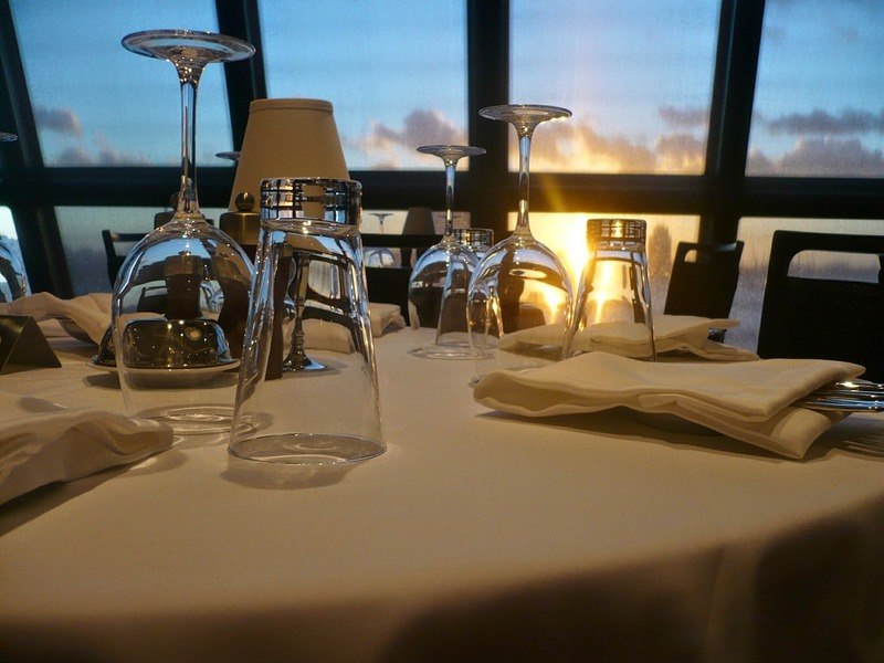 There's nothing like a sunset to set the perfect mood on a luxury cruise Wine glasses on a table at sunset on a cruise