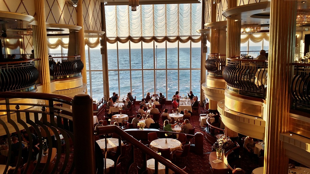 You won't have to spend all your time in the main dining room if you save more on cruise fare A lavish and elegant dining room with interior balconies and floor to ceiling windows overlooking the ocean